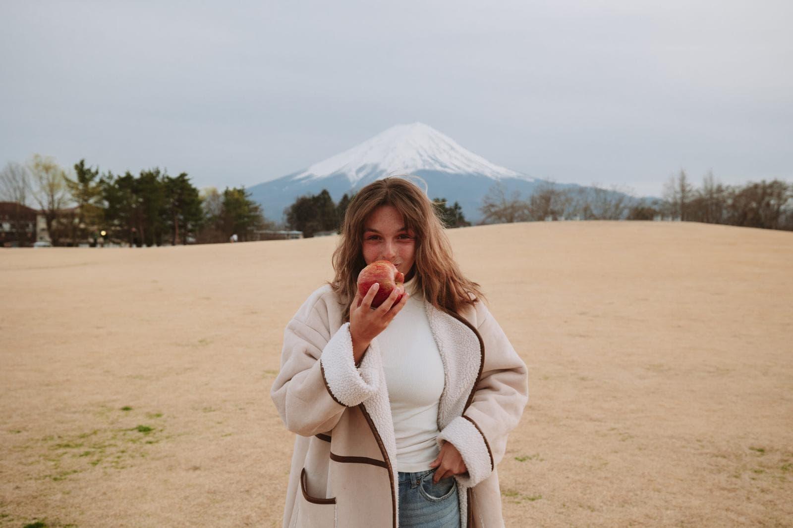 Girl eating a Fuji Apple at Kaguzaki Park with Mt Fuji in the background