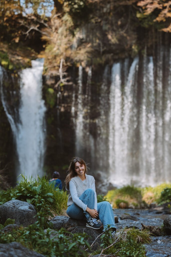 Woman sitting in front of shiraito falls