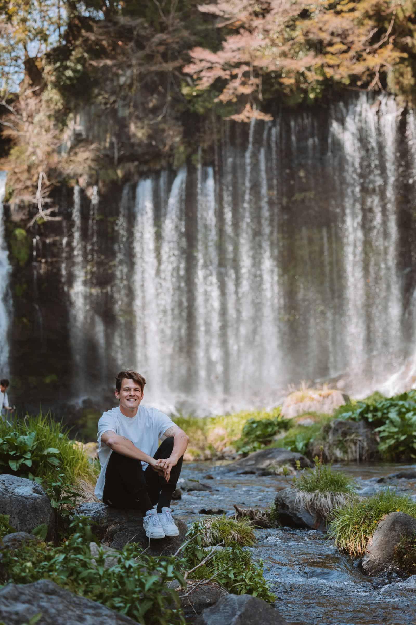 Man sitting in front of Shiraito Falls