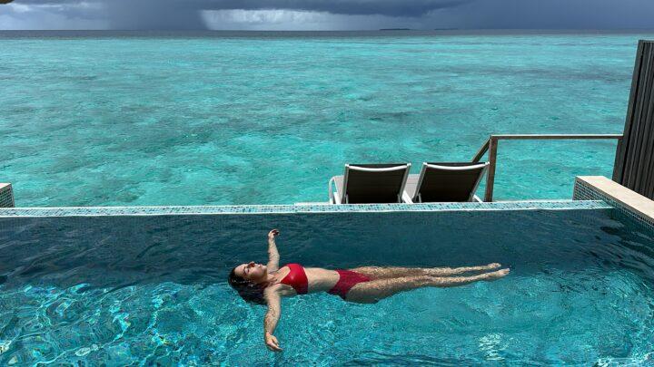 girl floating in infinity pool of the Cora Cora Maldive Lagoon Pool Villa