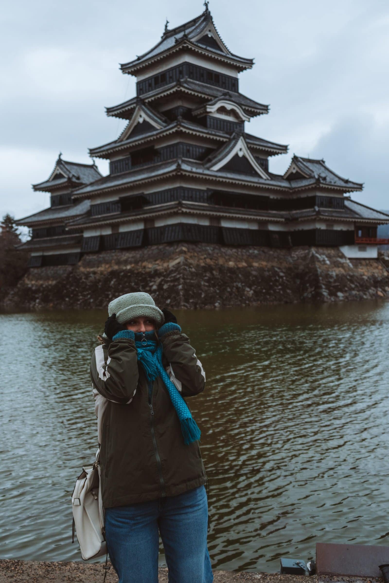 Girl standing in front of Matsumoto castle in winter